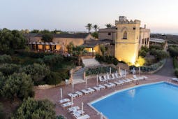 Baglio Oneto pool, pool deck with sun loungers, hotel building in background, traditional architectural features