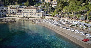 Villa Sant Andrea Sicily aerial shot of beach and  sun loungers umbrellas