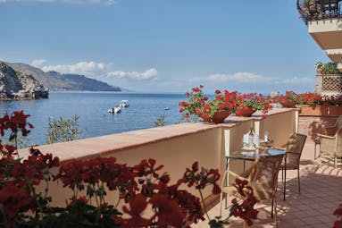 Villa Sant Andrea Sicily balcony outdoor seating area red flowers sea views