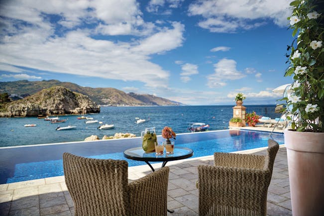 Villa Sant Andrea Sicily infinity pool and outdoor seating area overlooking sea