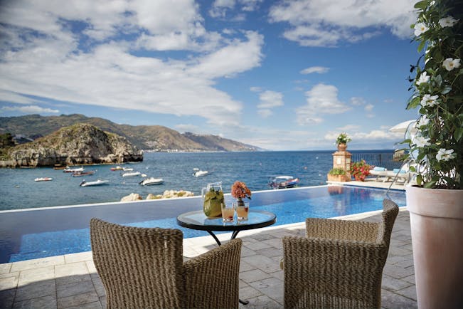 Villa Sant Andrea Sicily infinity pool and outdoor seating area overlooking sea