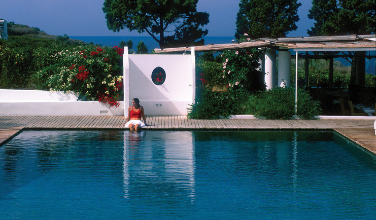 Capofaro Hotel Sicily pool women dipping her legs in the water sea in background