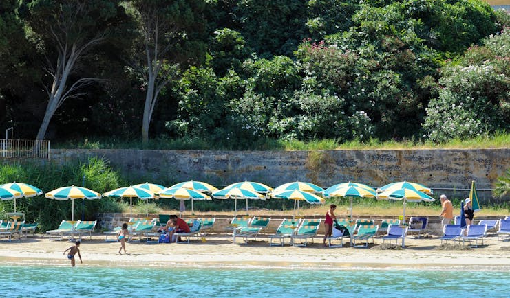 Beach with umbrellas and deck chairs laid out on the sand near the sea