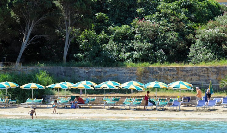 Beach with umbrellas and deck chairs laid out on the sand near the sea