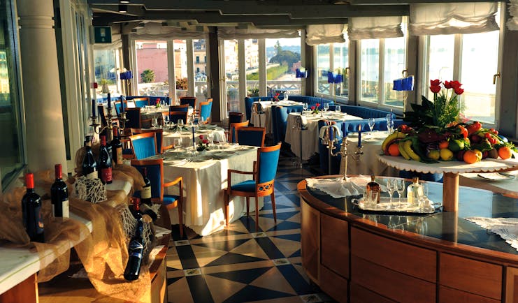 Restaurant with dining tables set out around the room and a fresh fruit platter