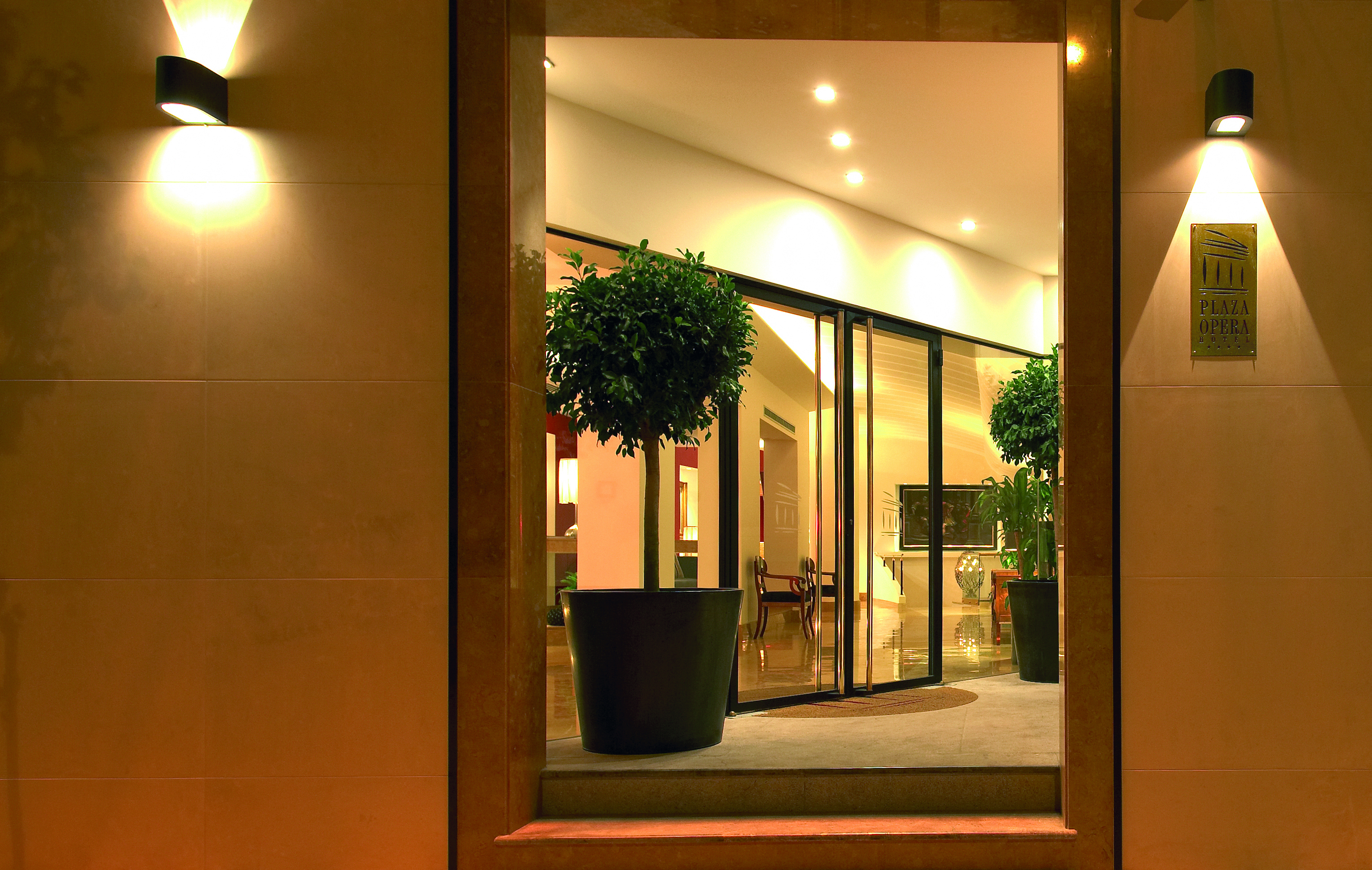 View of the entrance of the Hotel Plaza Opera with plants shown surrounding the doors