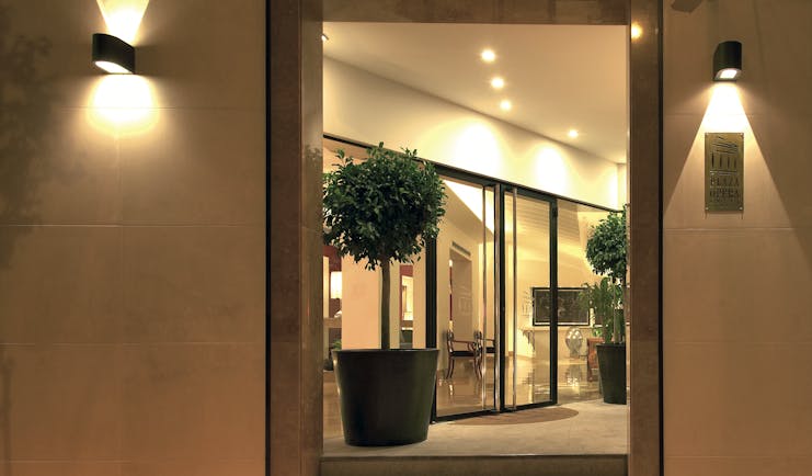 View of the entrance of the Hotel Plaza Opera with plants shown surrounding the doors