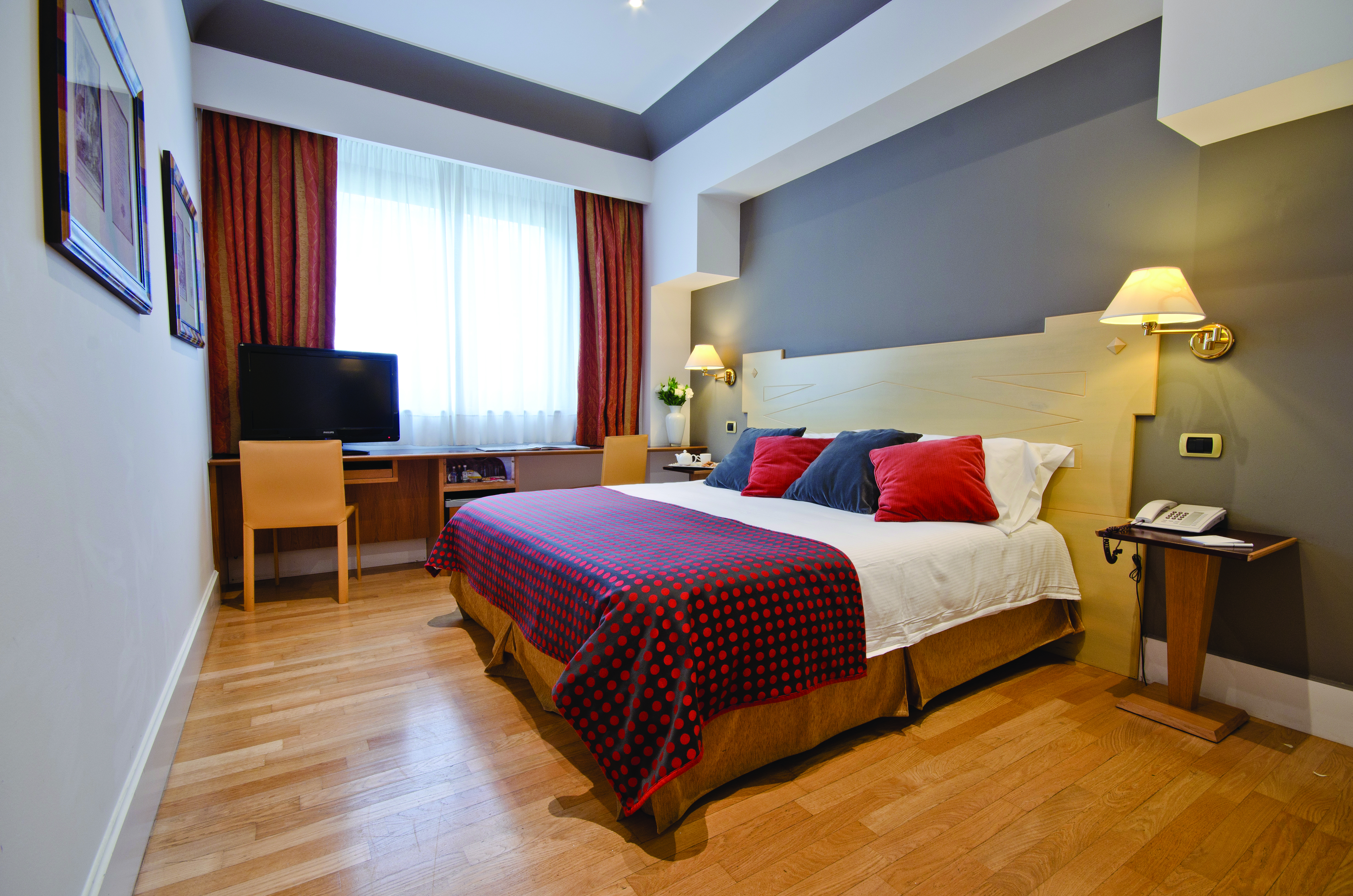 Superior double room at the Hotel Plaza Opera with a large bed, television and large windows