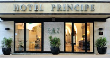 Hotel Principe di Villafranca entrance, hotel name, glass doors, lit up lobby