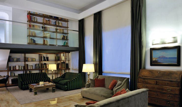Hotel Principe di Villafranca library, communal seating area, bookshelves, low velvet sofas, elegant decor