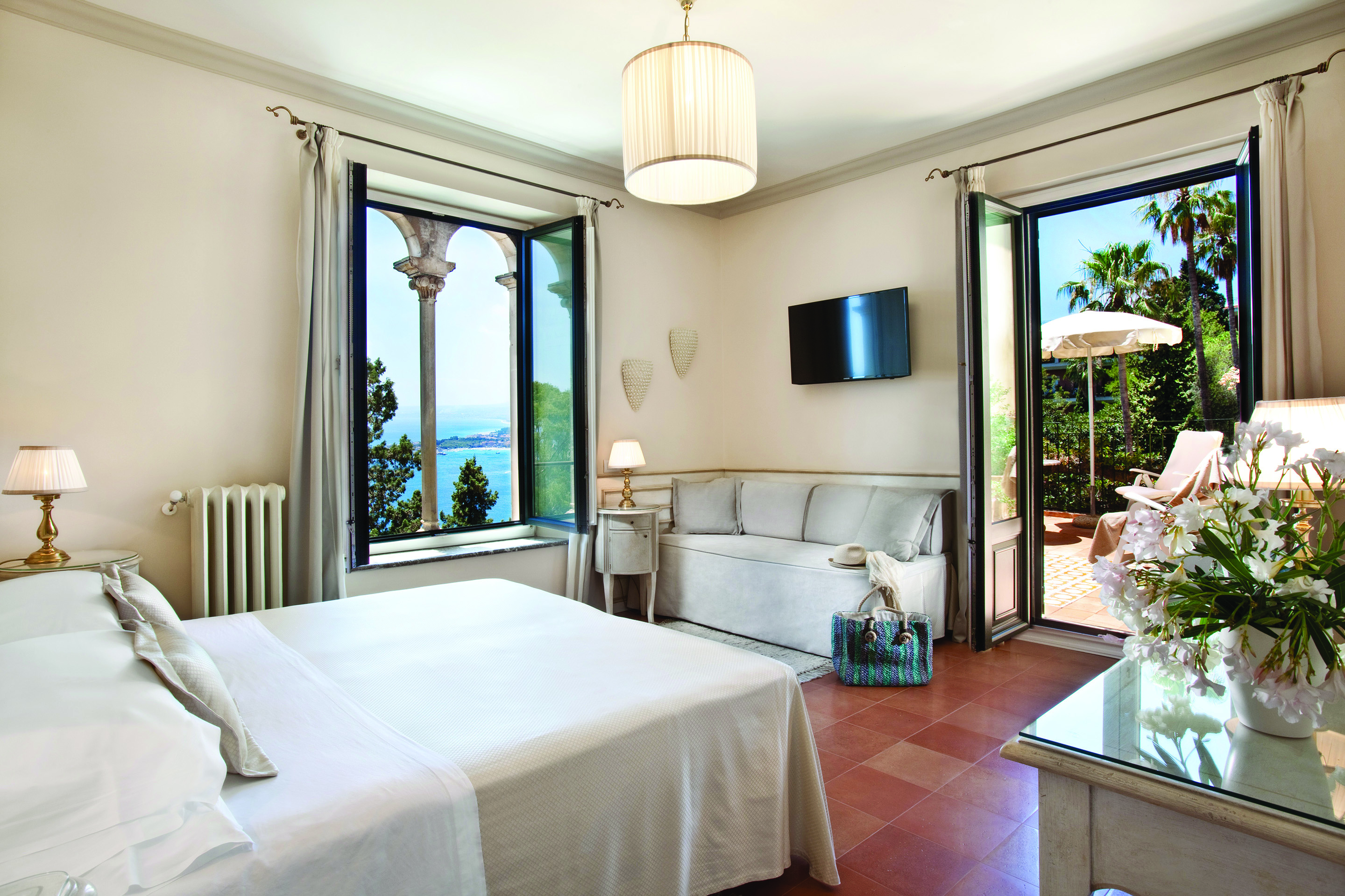 Hotel Villa Belvedere Sicily terrace suite bedroom sofa doors leading to terrace side view of ocean