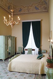 Double room with chandelier, large double bed and draping velvet curtains