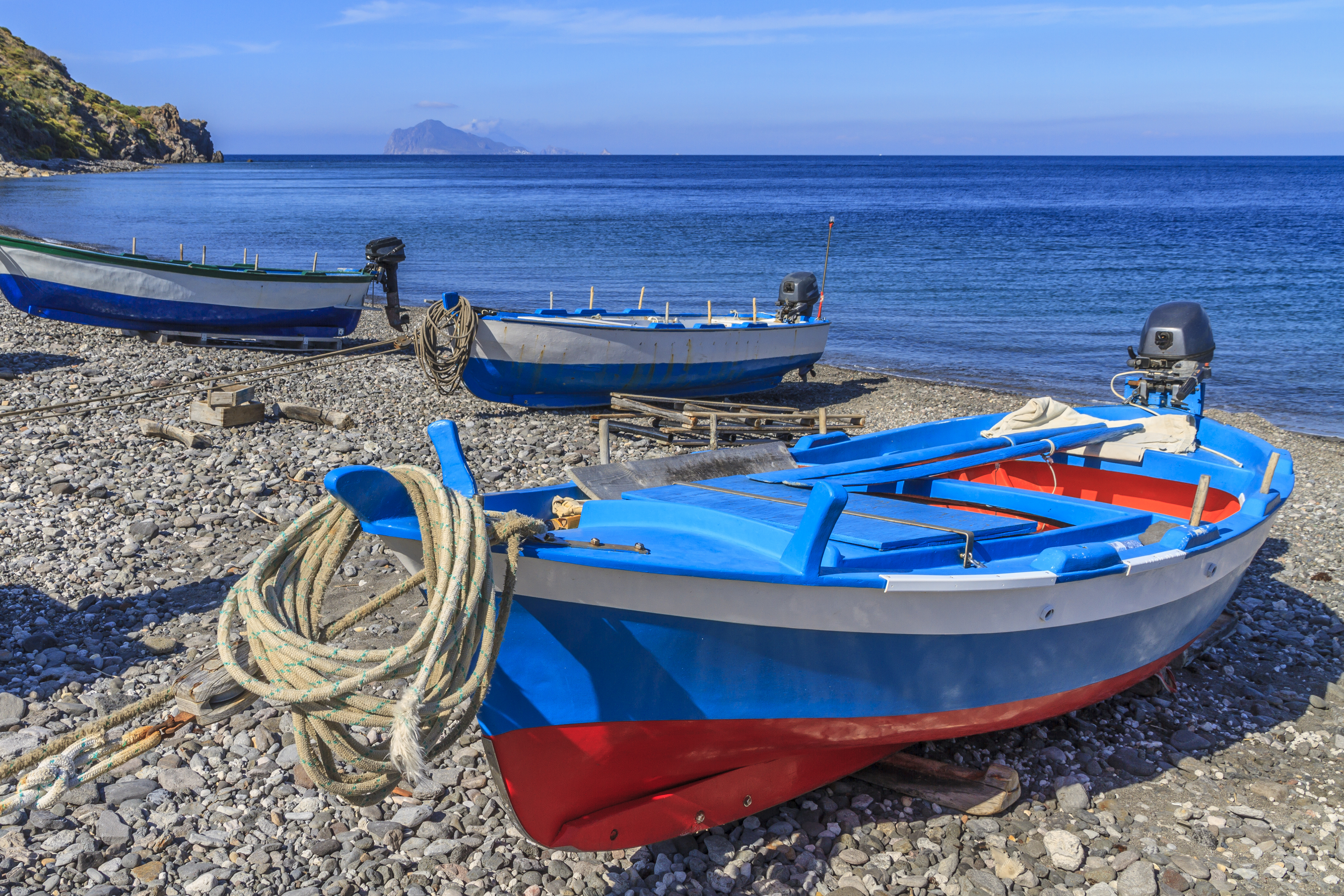 Red and blue fishing boat on pebble beach on Lipari in the Sicilian Aeolian Islands