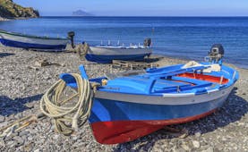 Red and blue fishing boat on pebble beach on Lipari in the Sicilian Aeolian Islands