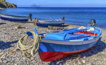 Red and blue fishing boat on pebble beach on Lipari in the Sicilian Aeolian Islands