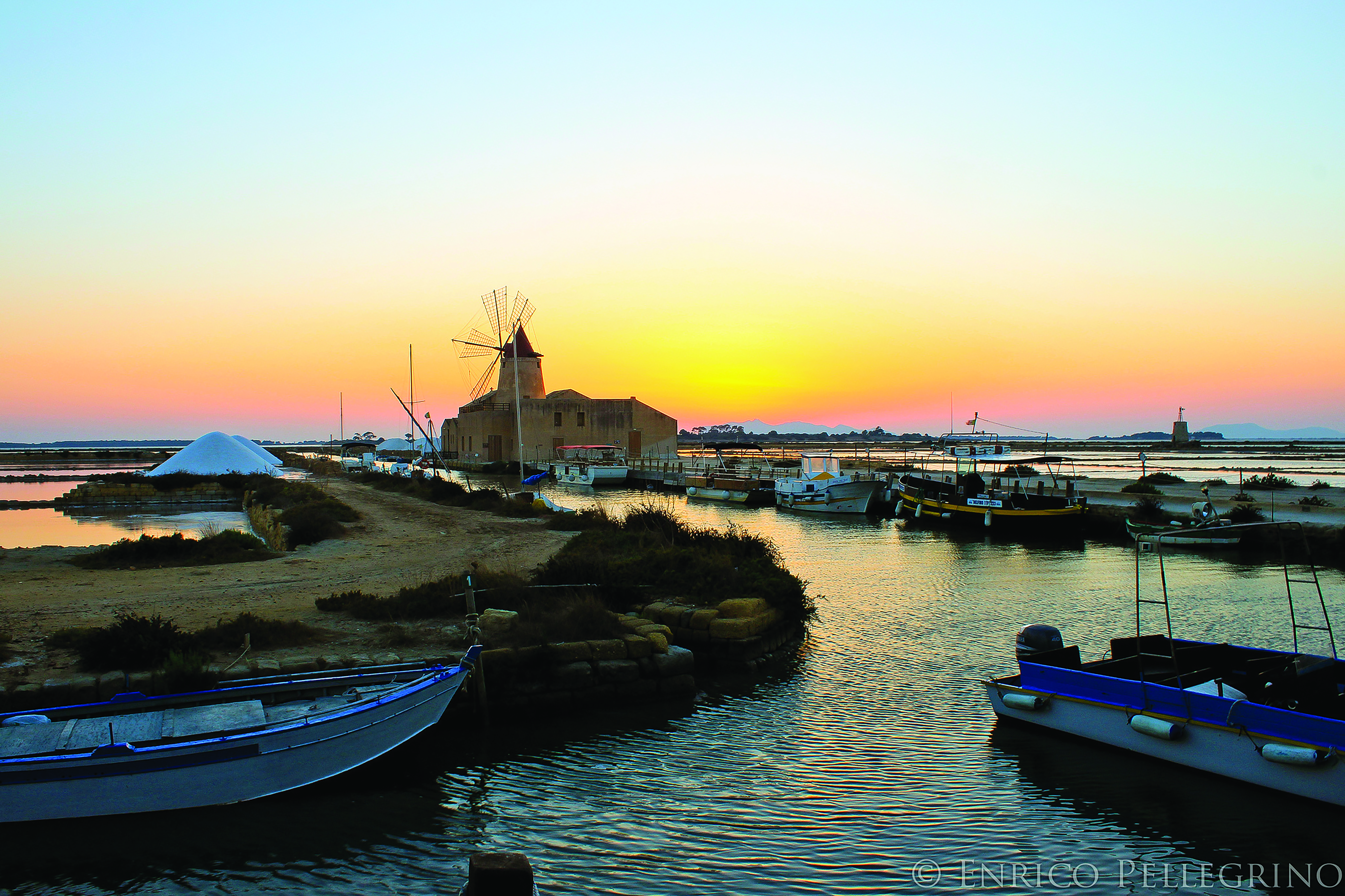 Sunset view of windmill by sea