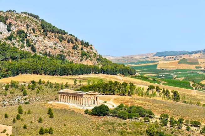 Ancient Greek temple in dry landscape and rocky hills at Segesta in Sicily