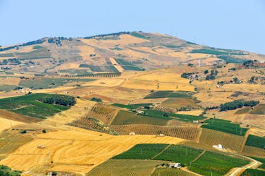 Patchwork of yellow, green and brown fields with hills in Sicily