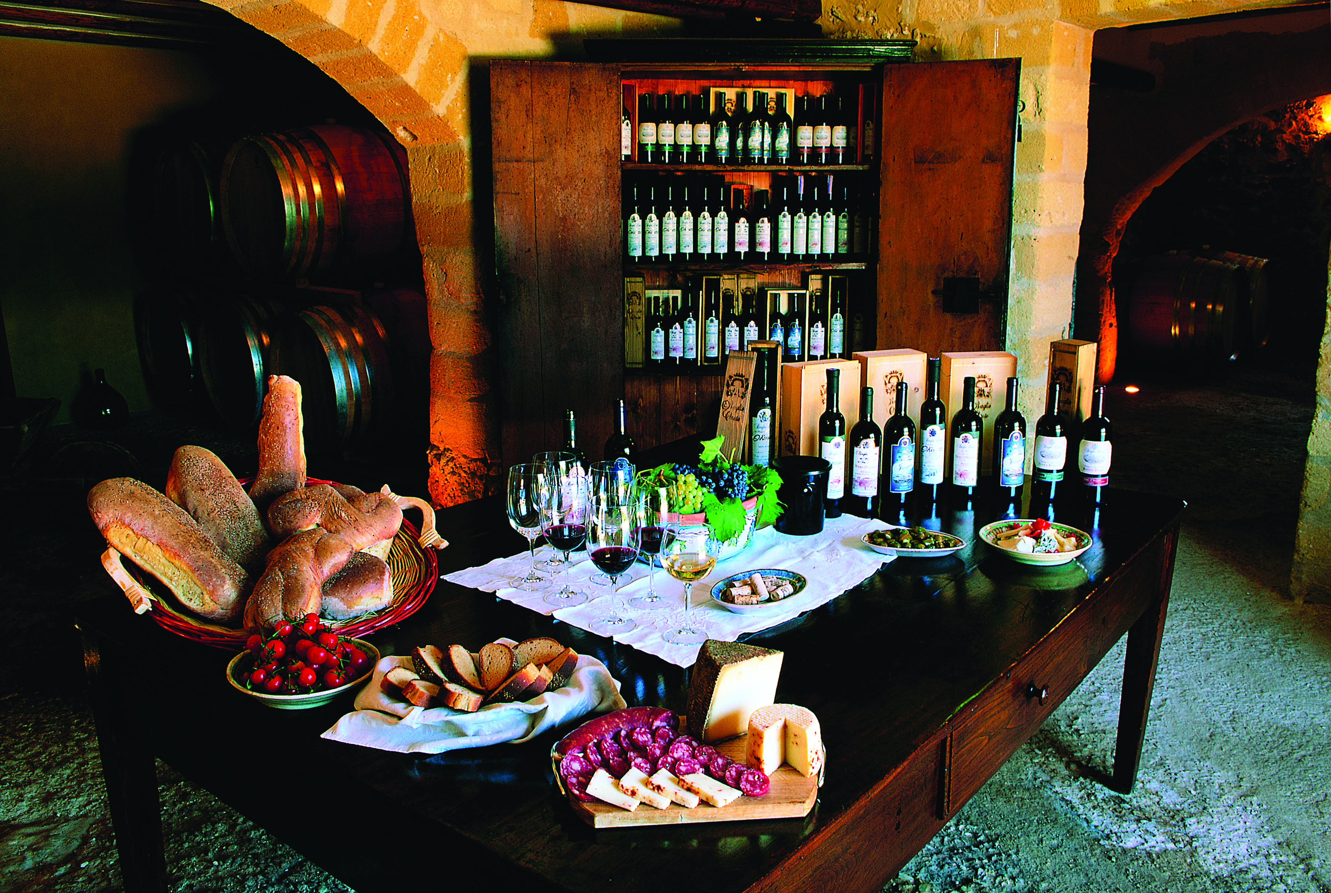 Bottles of wine and cold cuts and bread for tasting on table