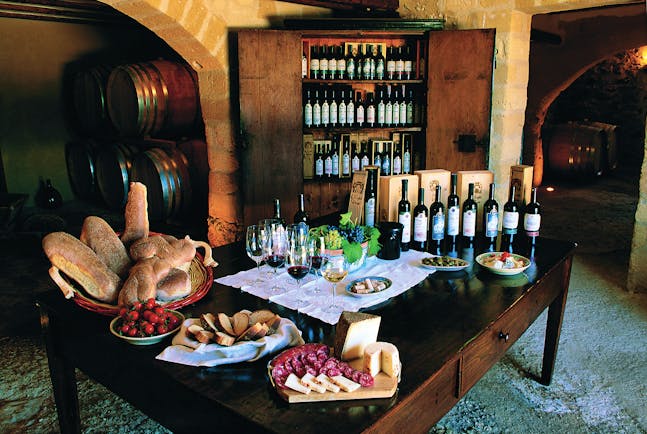 Bottles of wine and cold cuts and bread for tasting on table