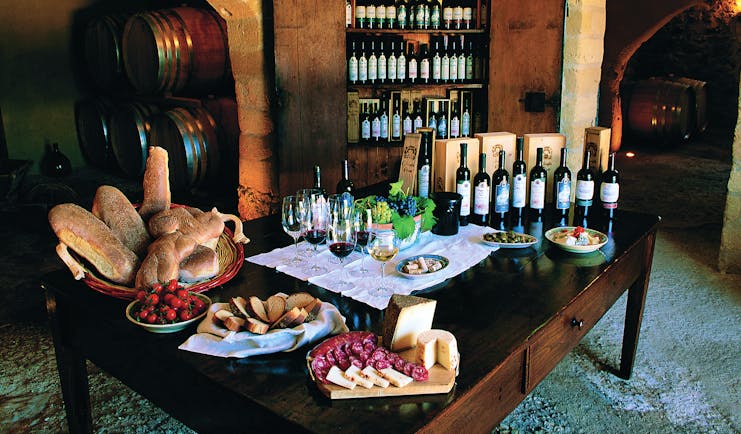 Bottles of wine and cold cuts and bread for tasting on table