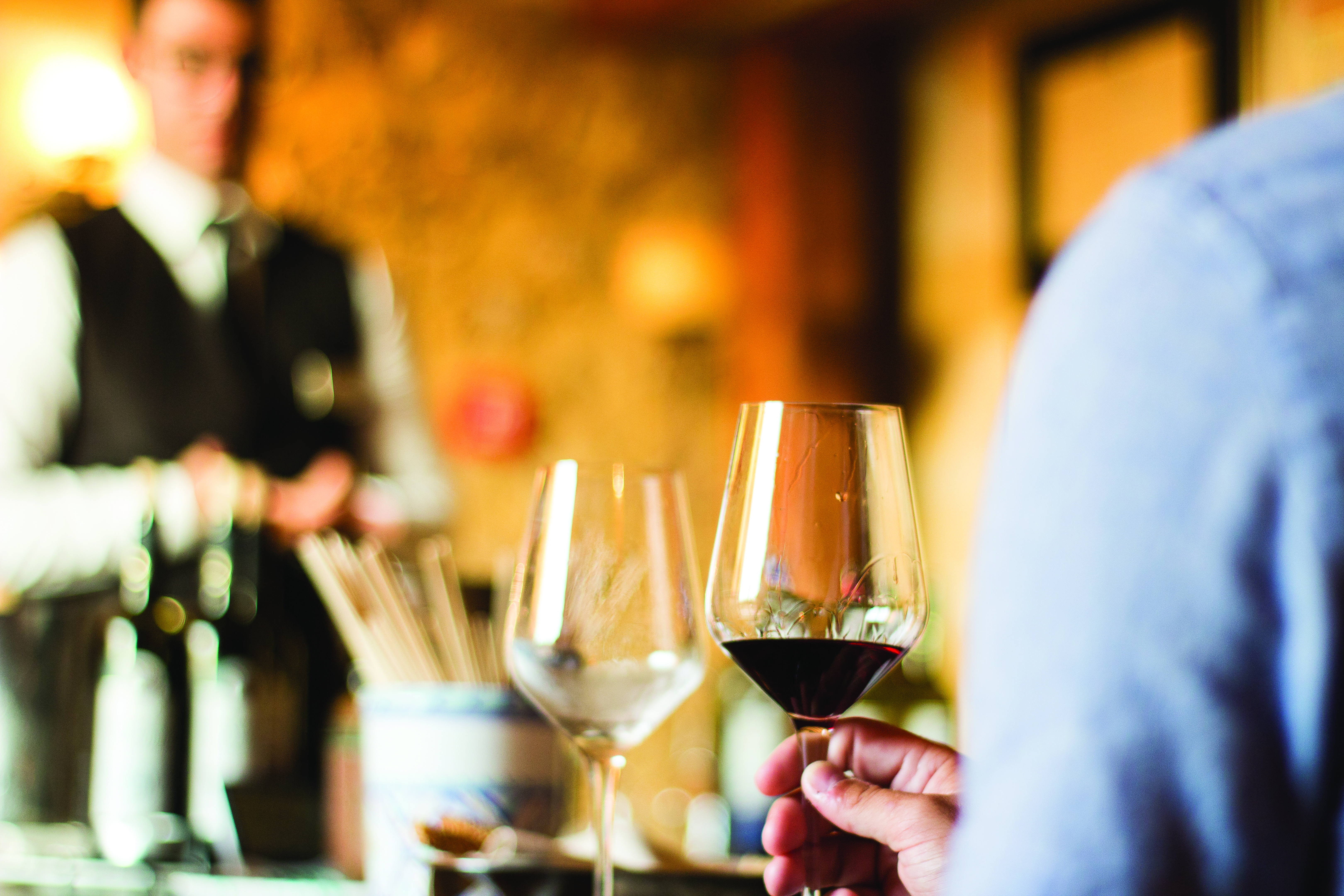 Waiter with wine bottles and glasses for tasting