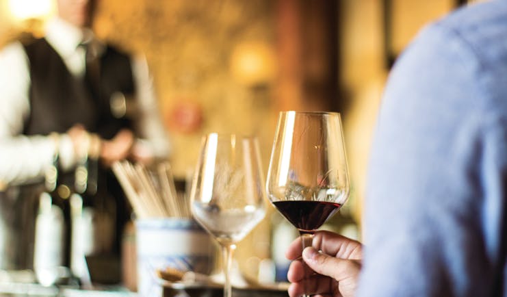 Waiter with wine bottles and glasses for tasting