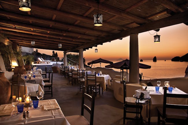 Therasia Resort Sicily dining terrace outdoor seating overlooking beach and Faraglione rocks