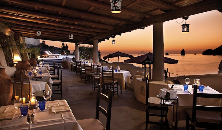 Therasia Resort Sicily dining terrace outdoor seating overlooking beach and Faraglione rocks