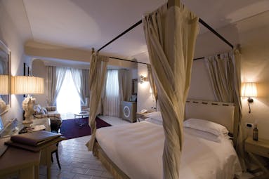Junior suite at the Therasia resort in Sicily with a cream and yellow colour scheme and large double bed