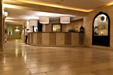 Reception area with beige colour scheme, dimly lit lights and stone walls and ceilings