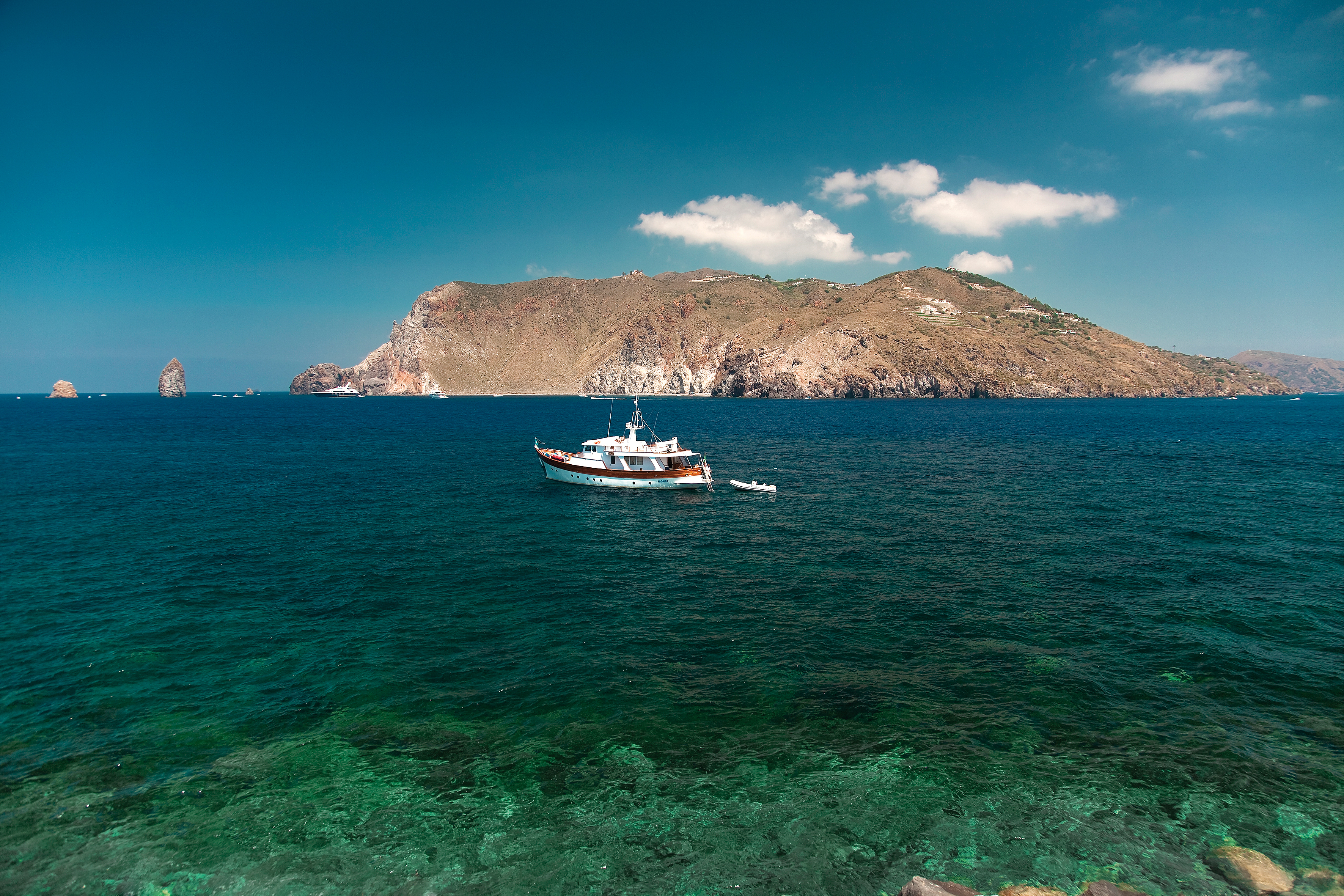 View of sea from hotel with boat and mountains in sea