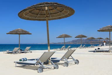 Verdura Resort white sand beach with sun beds and umbrellas
