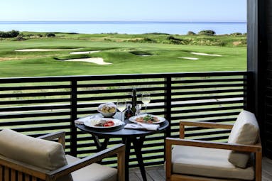 Verdura Resort balcony with two seats and view of golf course and sea