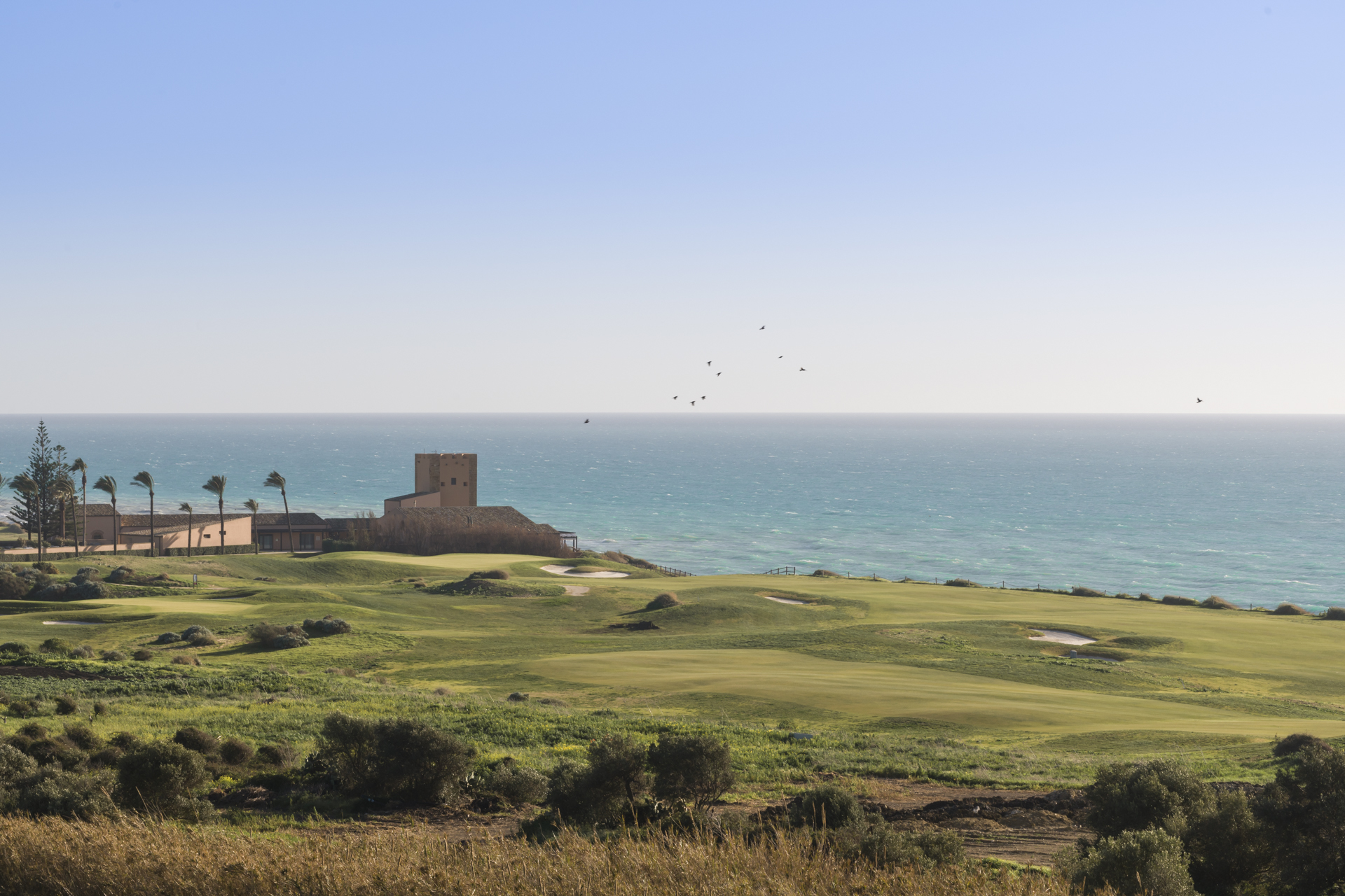Verdura Resort golf course, sea and palm trees