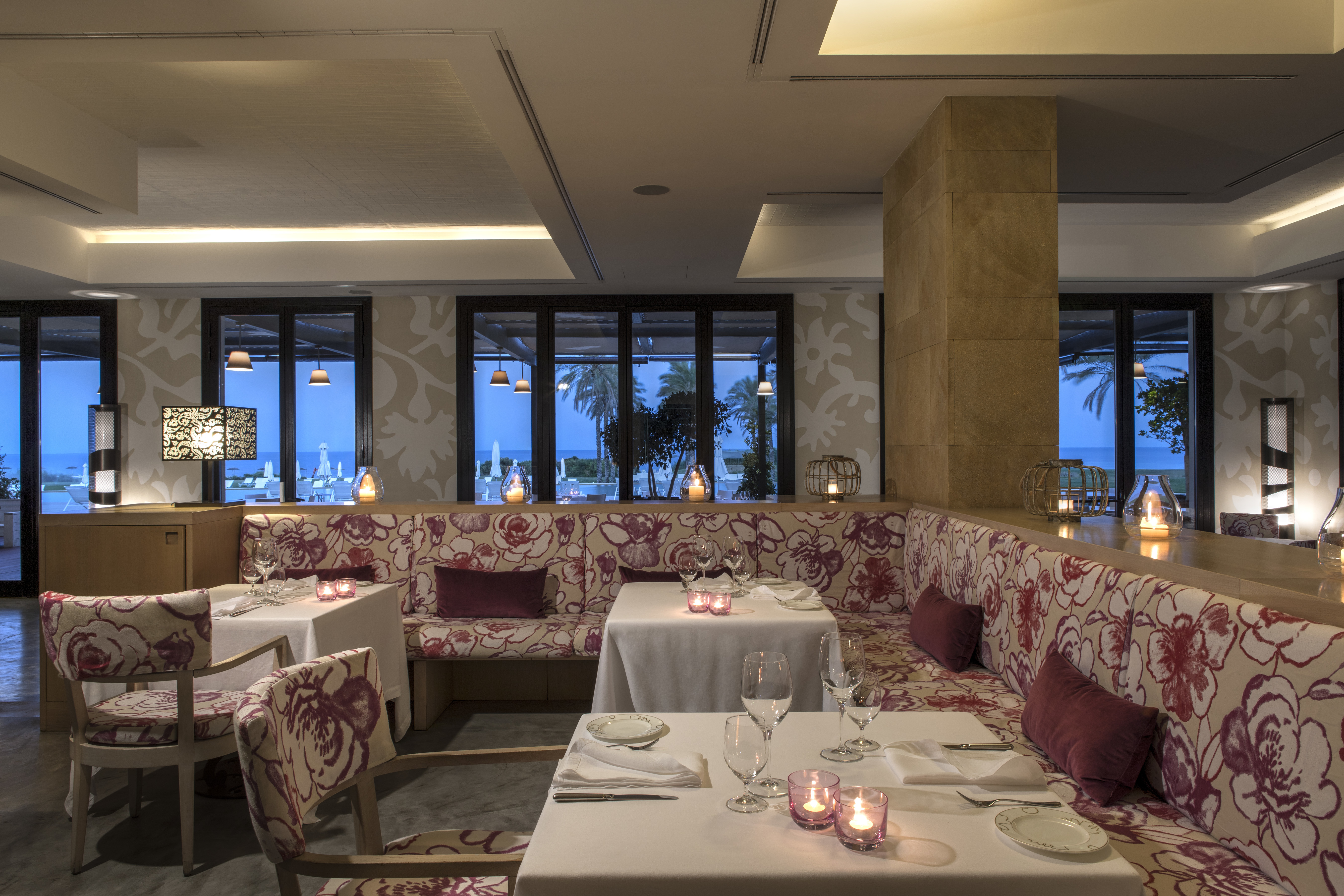 Verdura Resort indoor restaurant sea view with red and white seating