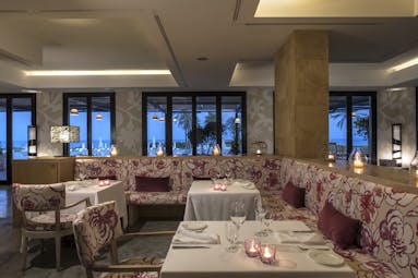 Verdura Resort indoor restaurant sea view with red and white seating