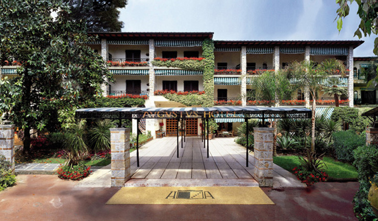 Augustus Hotel Tuscany exterior hotel entrance walkway hotel building lawns trees 
