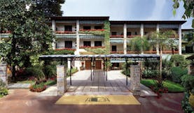 Augustus Hotel Tuscany exterior hotel entrance walkway hotel building lawns trees 