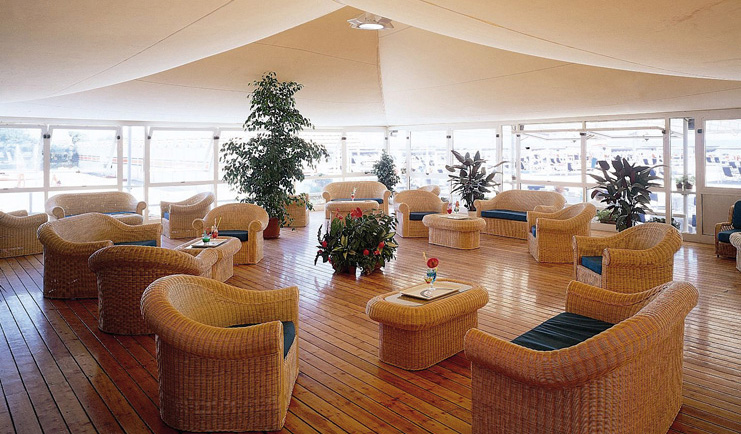 Augustus Hotel Tuscany restaurant indoor dining area wicker furniture