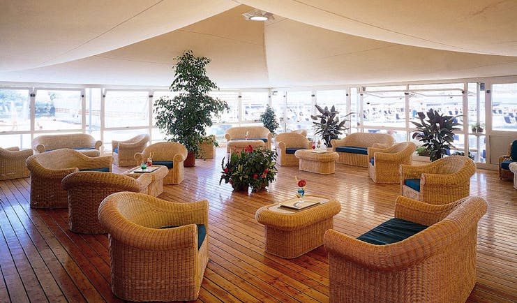 Augustus Hotel Tuscany restaurant indoor dining area wicker furniture