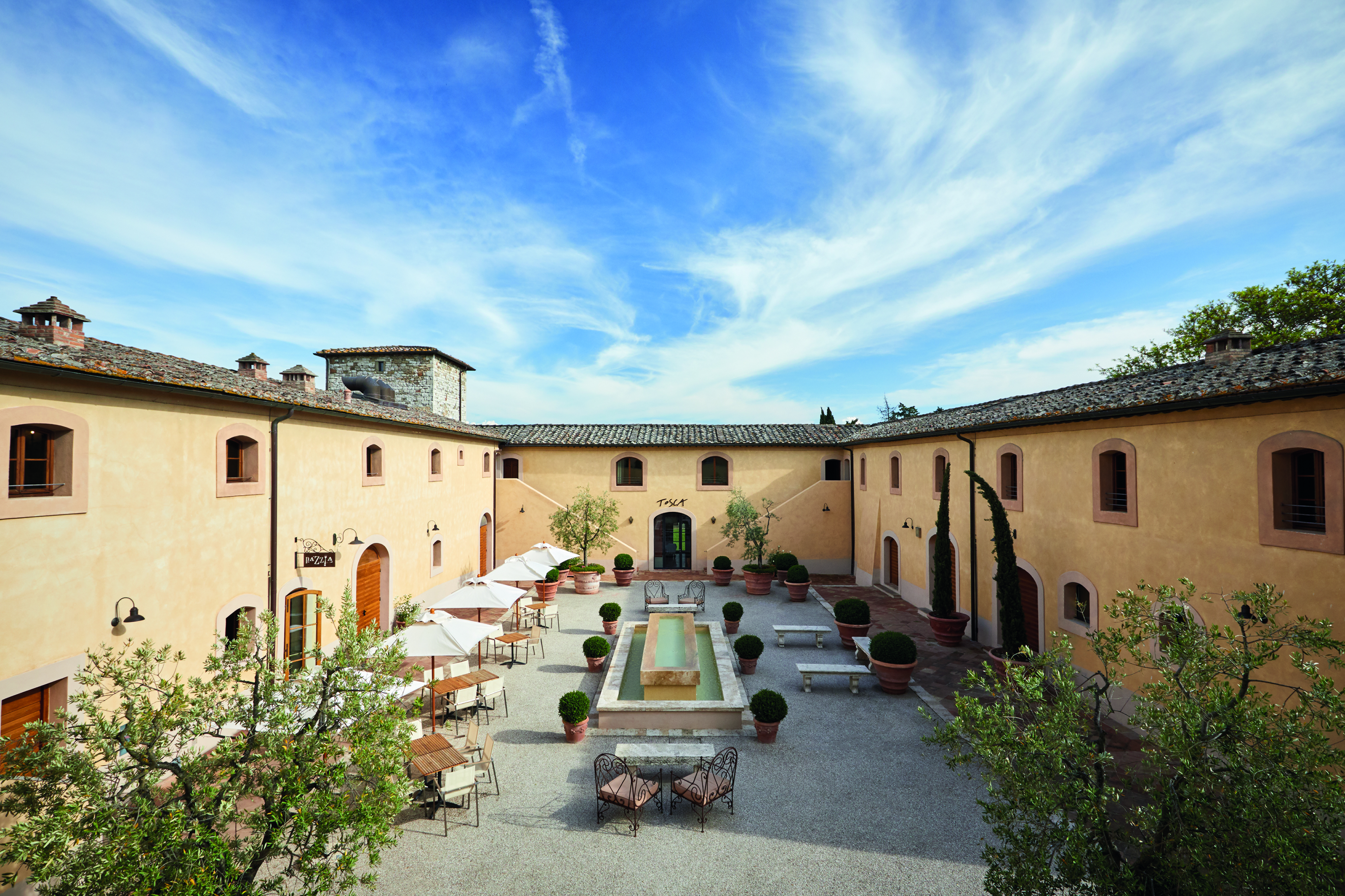 Belmond Castello di Casole Tuscany courtyard daytime outdoor seating water feature