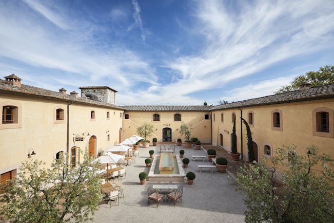 Belmond Castello di Casole Tuscany courtyard daytime outdoor seating water feature