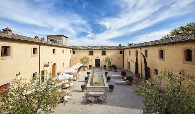 Belmond Castello di Casole Tuscany courtyard daytime outdoor seating water feature