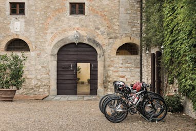 Borgo Pignano Tuscany bikes helmets gravel courtyard