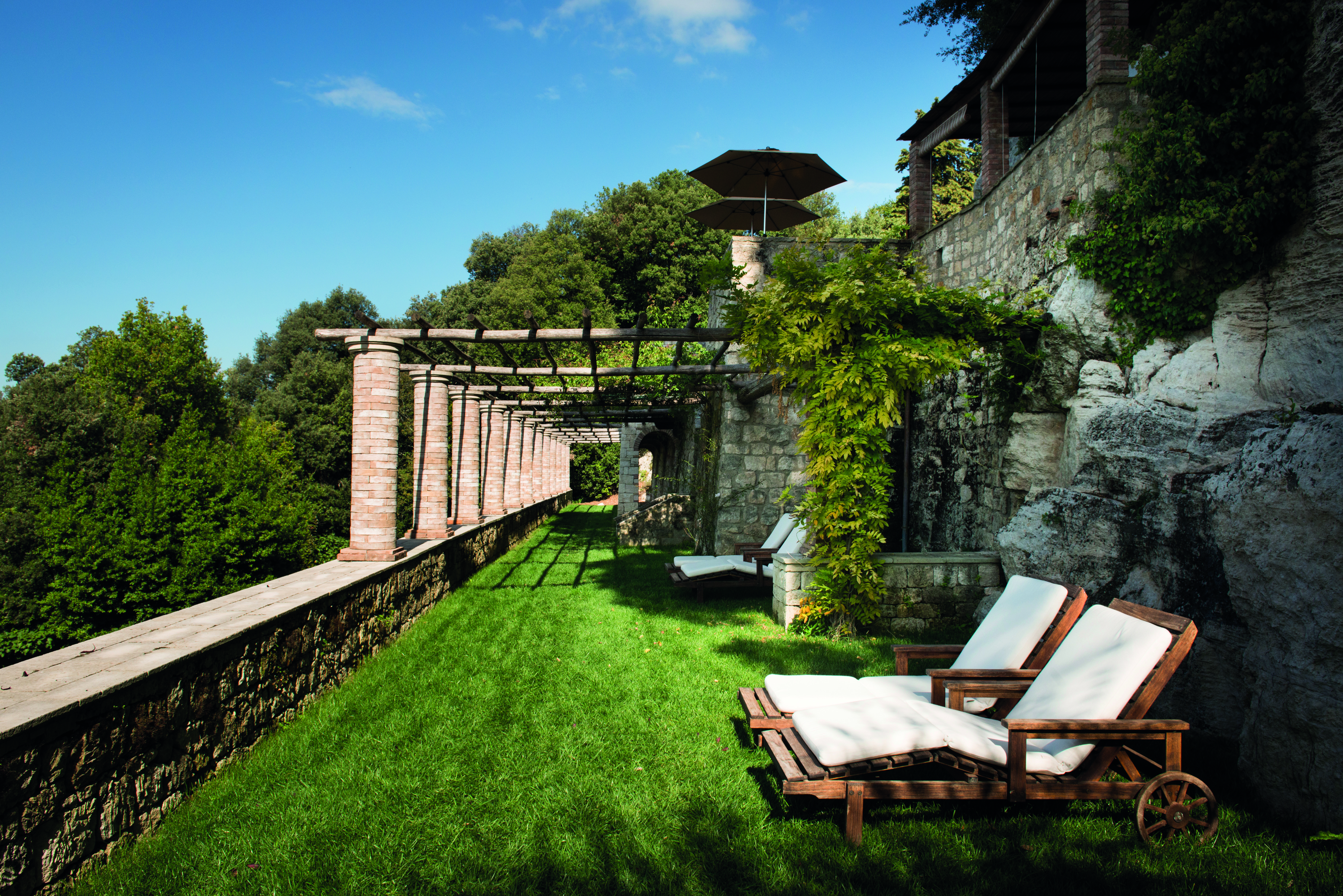 Borgo Pignano Tuscany grassy terrace outdoor seating area sun loungers 