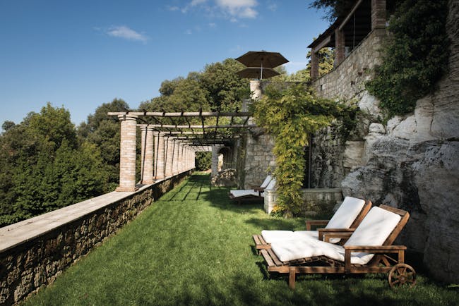 Borgo Pignano Tuscany grassy terrace outdoor seating area sun loungers 