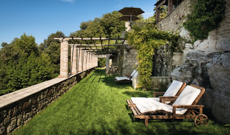 Borgo Pignano Tuscany grassy terrace outdoor seating area sun loungers 
