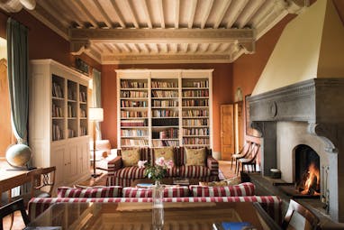 Borgo Pignano Tuscany library sofas fire bookshelves cosy décor