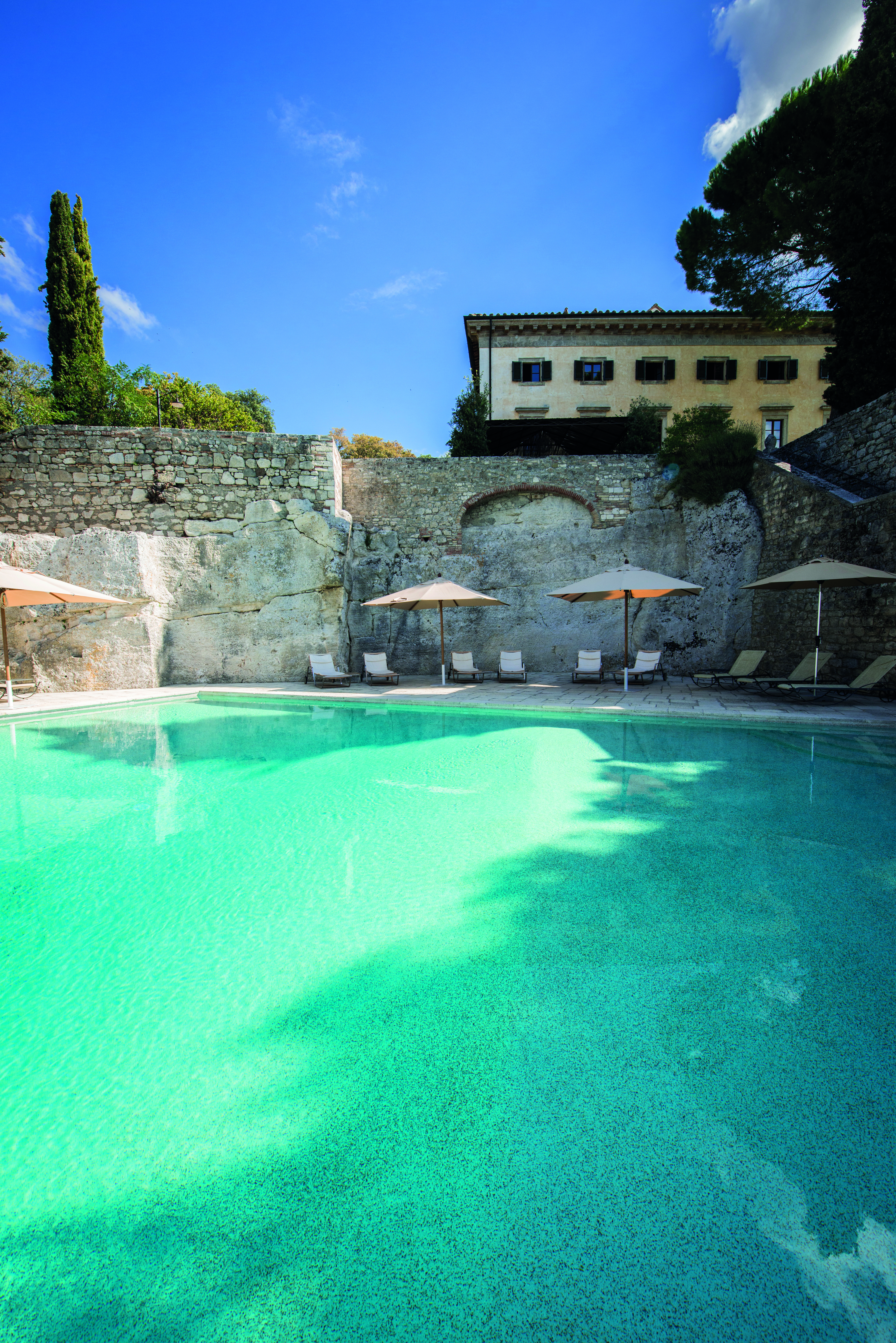 Borgo Pignano Tuscany pool sun loungers umbrellas 